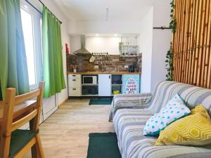 a living room with a couch and a kitchen at Pé n' Areia by Ericeira Property in Carvoeira