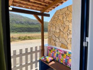 a porch with a rock wall and a window at Pé n' Areia by Ericeira Property in Carvoeira