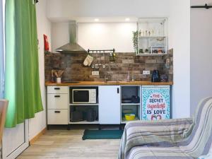 a small kitchen with a sink and a microwave at Pé n' Areia by Ericeira Property in Carvoeira +30 photos