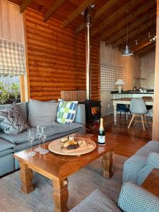 a living room with a couch and a table with wine glasses at Loerie Lodge in Keurboomstrand