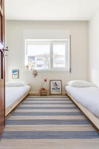 two beds in a room with a striped carpet at Porto Lidador Boutique Ap with Garden - Alvaro in Porto