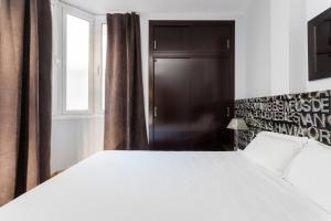 a bedroom with a large white bed and a window at The Best Barcelona in Barcelona