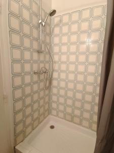 een badkamer met een douche met witte tegels bij Appartement 4 personnes au centre Paris - Chatelet in Parijs
