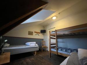 a bedroom with two bunk beds and a desk at Kapten Billes Restaurang och Logi in Norsholm