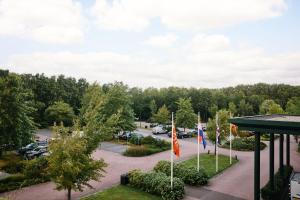 an aerial view of a parking lot with flags at Van der Valk Hotel Sneek in Sneek