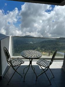 a table and two chairs on a balcony with a view at Premium Family 3BR Genting Ion Delemen in Genting Highlands