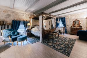 - une chambre avec un lit à baldaquin et une chaise bleue dans l'établissement Idyllischer Bauernhof mit viel Charme, à Arnsdorf