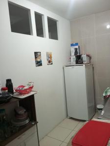 a small kitchen with a refrigerator and a table at Apartamento no Pelourinho in Salvador