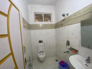 a small bathroom with a toilet and a sink at Hotel Plaza Rooms in Hyderabad