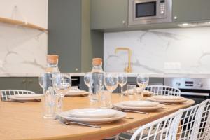 a wooden table with plates and wine glasses on it at 5-bedroom house in the centre of Lille. in Lille