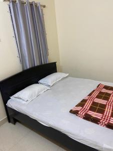 a bed with two pillows and a blanket on it at Hotel Plaza Rooms in Hyderabad