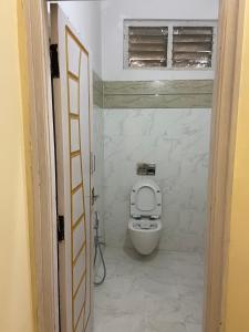 a bathroom with a toilet and a window at Hotel Plaza Rooms in Hyderabad