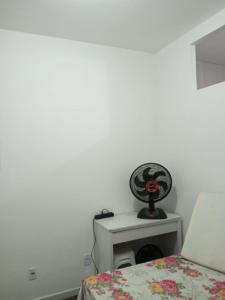 a bedroom with a bed and a white wall at Apartamento no Pelourinho in Salvador