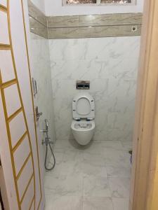 a white toilet in a bathroom with a window at Hotel Plaza Rooms in Hyderabad
