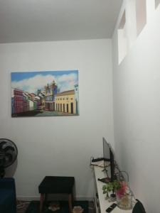 Apartamento no Pelourinho في سلفادور: غرفة مع مكتب مع لوحة على الحائط