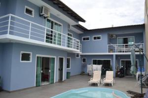 a blue house with a balcony and a swimming pool at Casa de Alto Padrão próxima ao Beto Carrero in Navegantes