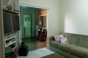 a living room with a couch and a sliding glass door at Casa de Alto Padrão próxima ao Beto Carrero in Navegantes