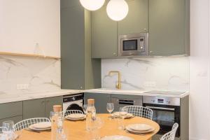 a kitchen with a table with chairs and a microwave at 5-bedroom house in the centre of Lille. in Lille +41 photos
