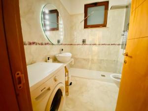 een badkamer met een wastafel, een spiegel en een bad bij Lucky’s house in Noicattaro