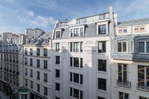 une rangée de bâtiments blancs dans une ville dans l'établissement Appartement Paisible Proximité des Halle - 4P, à Paris