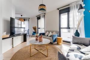 a living room with a couch and a table at Palais des congrès , 4 bedrooms in Levallois-Perret