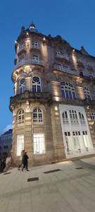 a man standing in front of a large building at Edificio El Moderno Puerta del Sol in Vigo