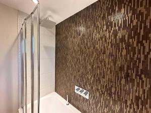 a bathroom with a shower and a tub with a tile wall at No.2 by Blue Skies Stays in Thornaby on Tees