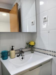 a white sink in a kitchen with a mirror at Alicante airport and beach in El Altet