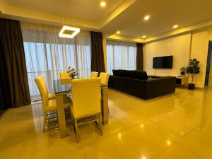 a living room with a table and yellow chairs at Premium Family 3BR Genting Ion Delemen in Genting Highlands