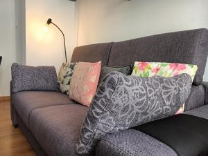 a couch with pillows on it in a living room at Alicante airport and beach in El Altet