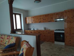 een keuken met houten kasten en een fornuis met oven bij APPARTAMENTO ACERO ROSSO 