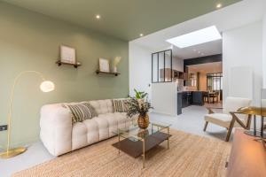 ein Wohnzimmer mit einem Sofa und einem Tisch in der Unterkunft 3 bedroom house with garden, free parking in Marcq-en-Baroeul