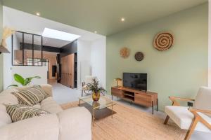 sala de estar con sofá y TV en 3 bedroom house with garden, free parking en Marcq-en-Baroeul