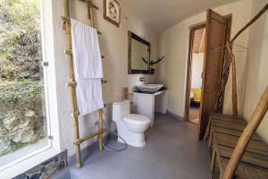 a bathroom with a toilet and a window at Sukoon, Bhatrojkhan, Near Ranikhet, Uttarakhand in Tota Ām