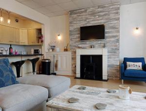 a living room with a couch and a fireplace at Beach Front Apartment in Tywyn in Tywyn