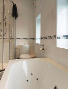陶因的住宿－Beach Front Apartment in Tywyn，带白色浴缸的浴室和卫生间