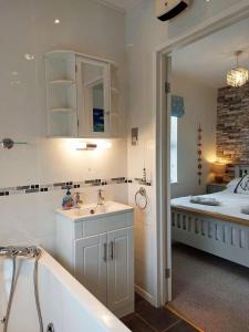 a bathroom with a sink and a tub and a bed at Beach Front Apartment in Tywyn in Tywyn