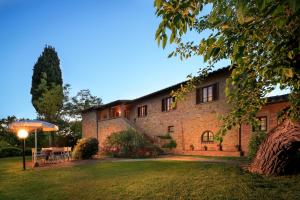 a large brick building with a lawn in front of it at Podere Fignano, holiday home - apartments, renovated 2024 in Montaione