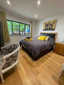 ein Schlafzimmer mit einem Bett und einem Stuhl darin in der Unterkunft Hendrix’s cottage in Lincoln