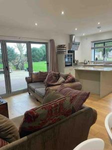 ein Wohnzimmer mit Couch und Küche in der Unterkunft Hendrix’s cottage in Lincoln