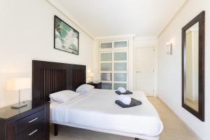 - une chambre avec un grand lit blanc et un miroir dans l'établissement Balcon los Gigantes Beautiful, à Puerto de Santiago
