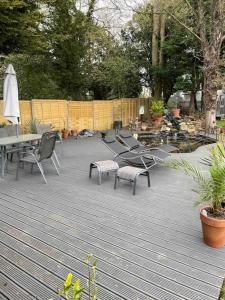 een patio met stoelen en tafels en een parasol bij Hendrix’s cottage in Lincoln