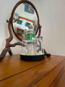 a bottle of water sitting on a table in front of a mirror at Hendrix’s cottage in Lincoln