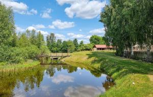 Un río con un puente y árboles y nubes en el cielo en 7 Bedroom Lovely Home In Szalstry en Szałstry