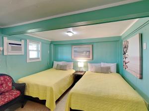 two beds in a room with blue walls at Flip Flop Beachside in Galveston