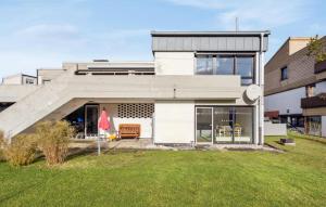 a modern house with a lawn in front of it at Pet Friendly Apartment In Meschede With Kitchen in Meschede