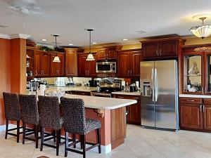 eine Küche mit Holzschränken und Geräten aus Edelstahl in der Unterkunft Boca Shores 314 in St Pete Beach + 6 Fotos