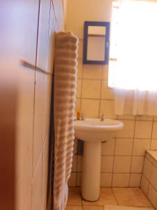 Baño con lavabo y toalla colgada en la puerta en Alldays Sunset Lodge, en Alldays