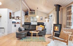 a living room with a leather couch and a fireplace at Awesome Home In Ebeltoft With Sauna in Ebeltoft