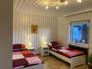 een slaapkamer met 2 bedden en een raam bij Ferienwohnung Weinbachtal in Wallerfangen